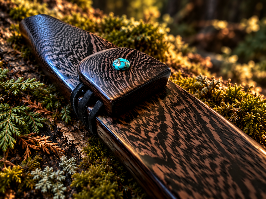 Wenge medicine flute with turquoise accent on a moss-covered forest log in warm golden light